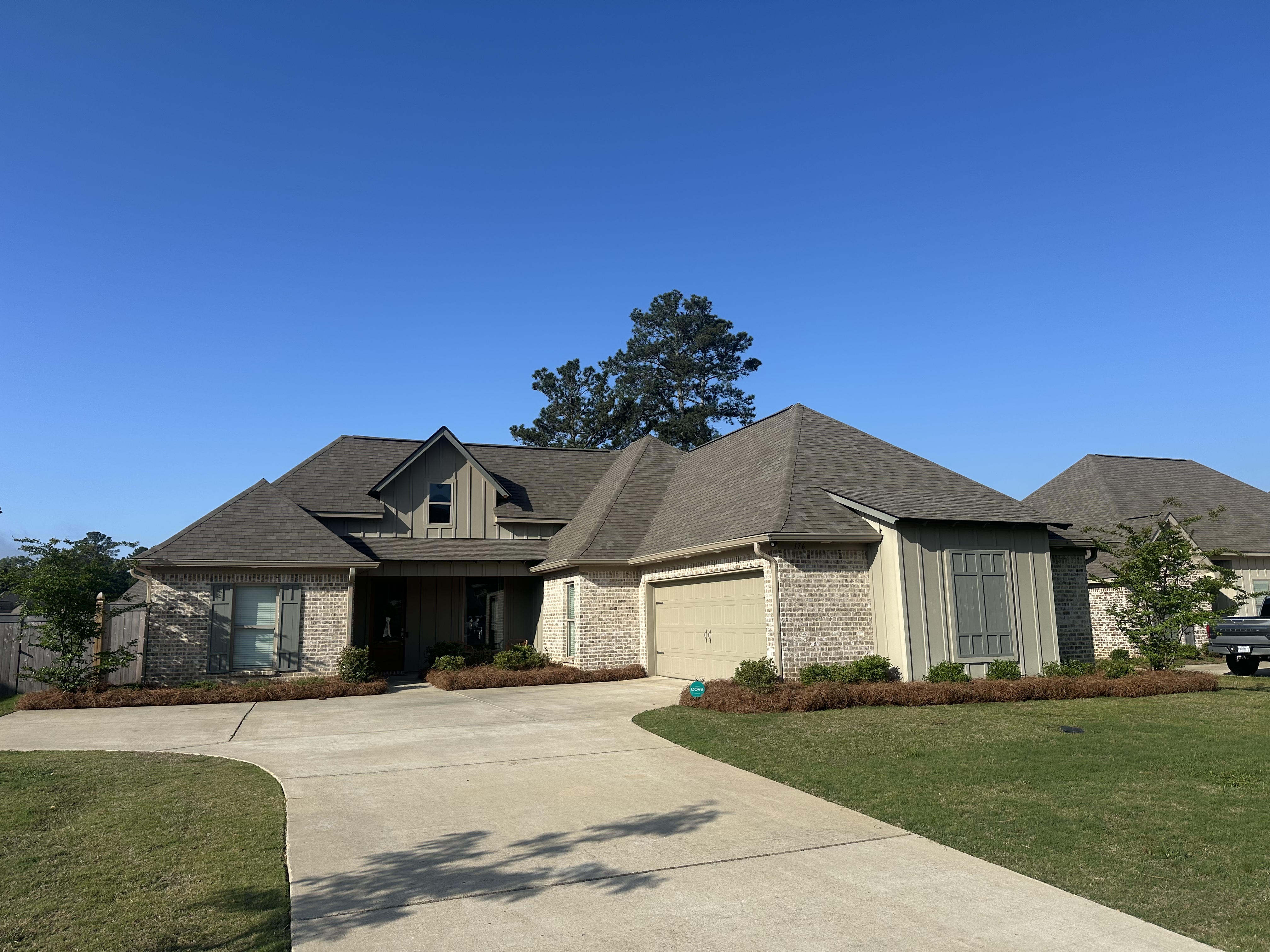 Cream brick home with pine straw beds